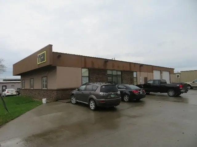 An office/warehouse with a paved lot — commercial building inspected by Nordic Inspections in Fargo, ND.