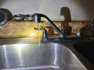 Frozen kitchen faucet with an icicle hanging from the spout in a North Dakota home