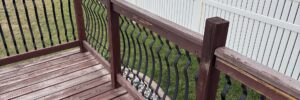 Wood deck guardrail with an arrow pointing to a loose post