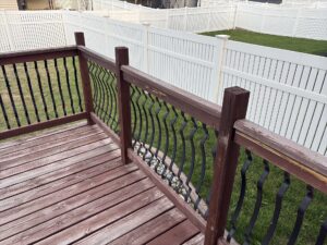 Wood deck guardrail with an arrow pointing to a loose post