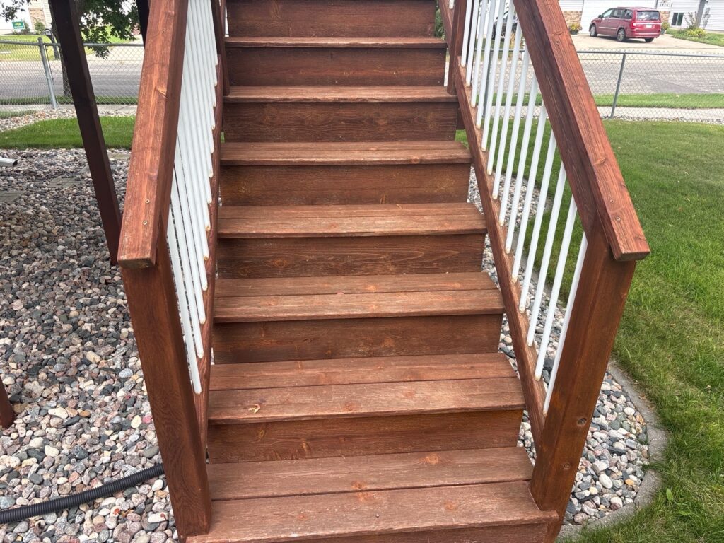 Wood deck stairs with arrows pointing to loose handrails on both sides